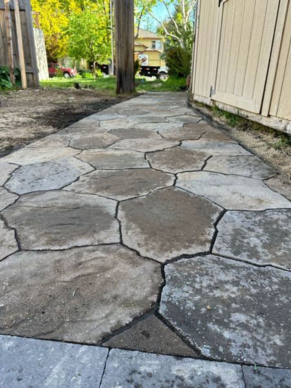 Close-up of a newly installed hexagonal stone pathway in a residential garden.